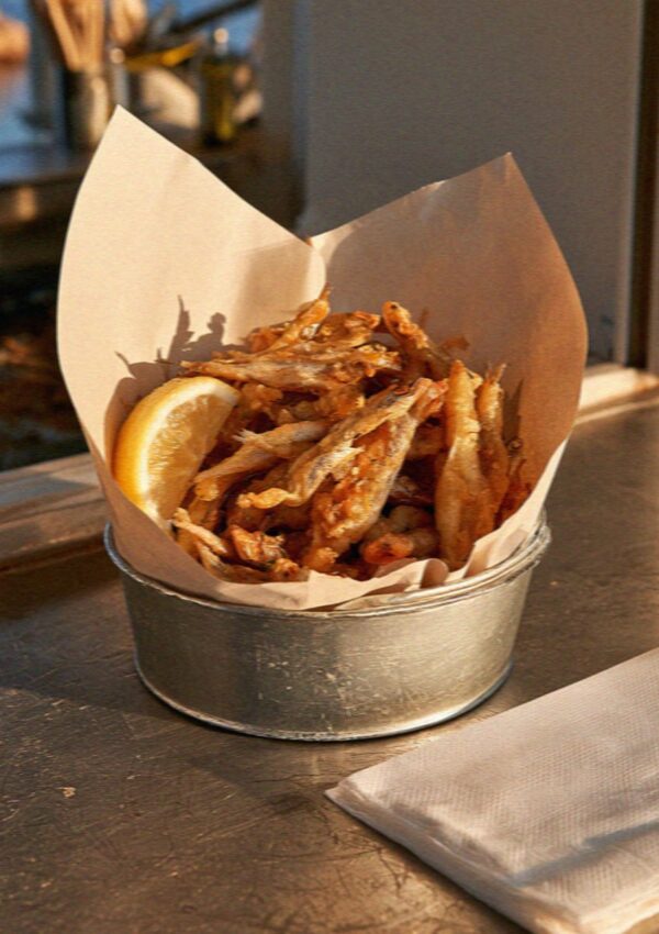 A tin of fried fish eaten standing up on the Costa Smeralda in Sardinia