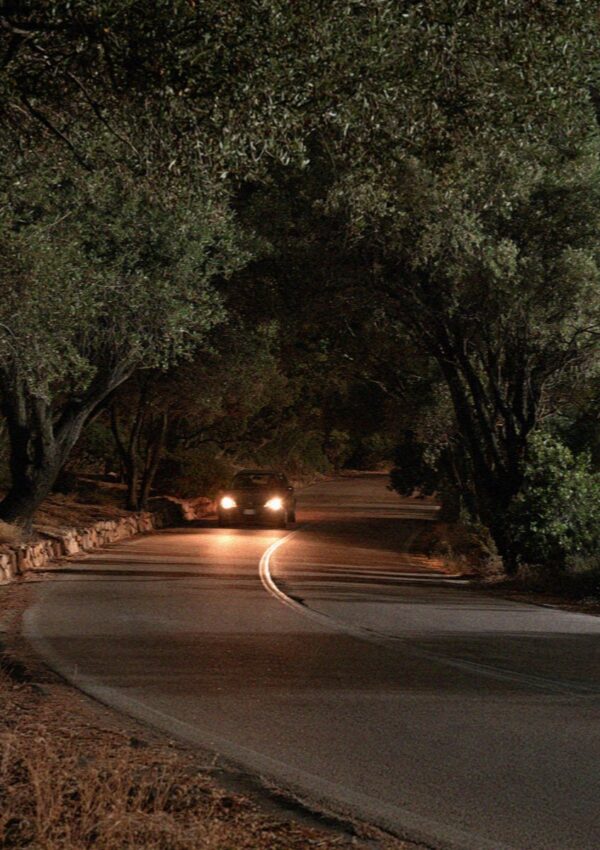 Headlights on the empty coast road at night on the Costa Smeralda in Sardinia