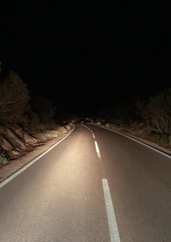 Headlights on the scrub on a dark road on the Costa Smeralda in Sardinia