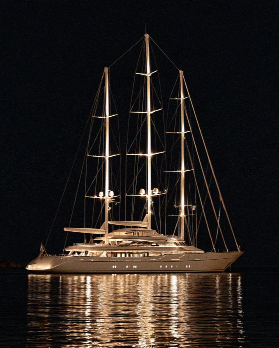 A lit yacht on flat black water at one in the morning on the Costa Smeralda in Sardinia