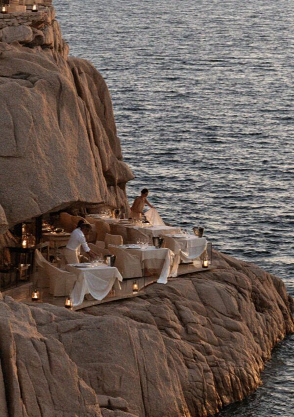 Candlelit tables set into the granite above the water on the Costa Smeralda in Sardinia