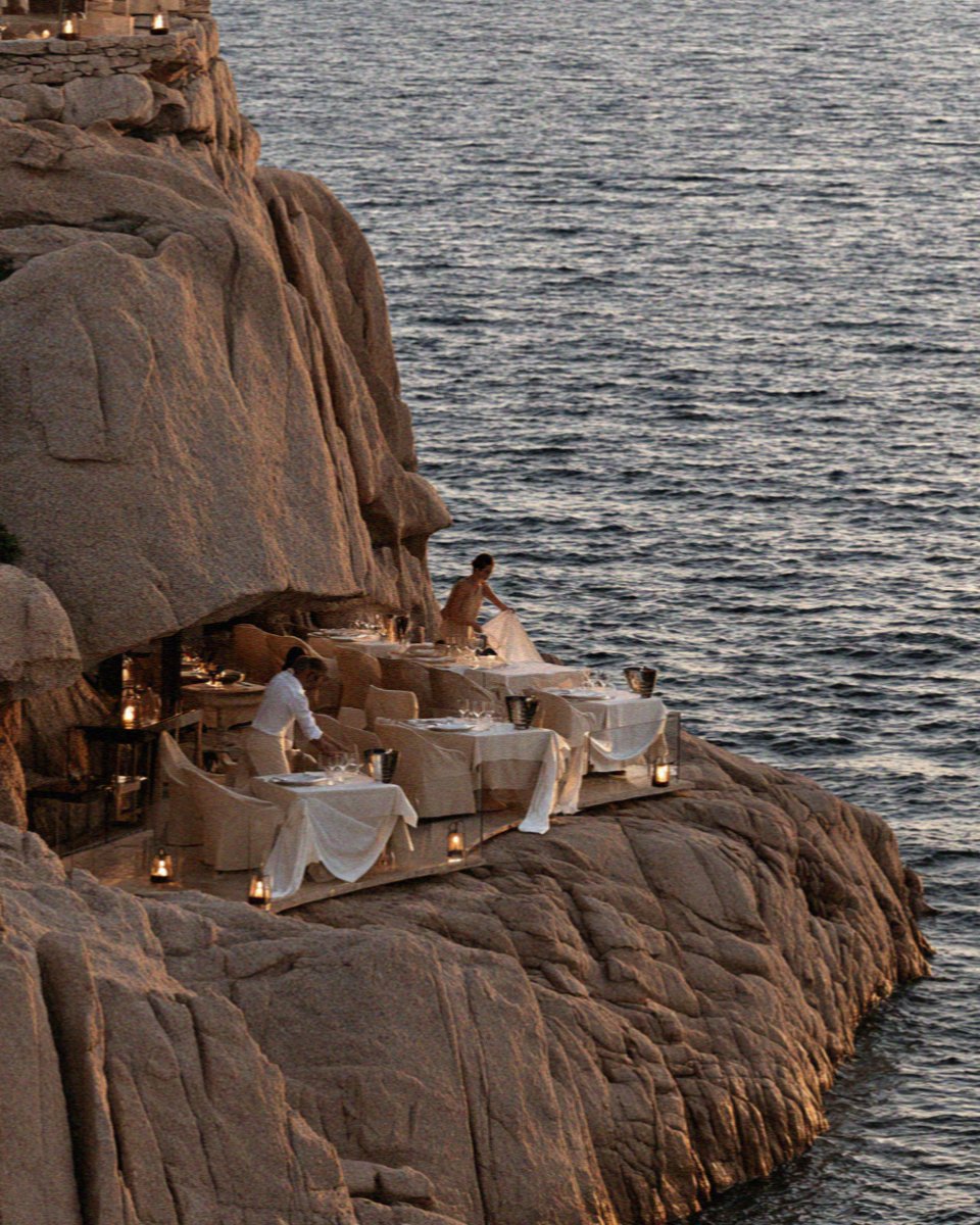 Candlelit tables set into the granite above the water on the Costa Smeralda in Sardinia
