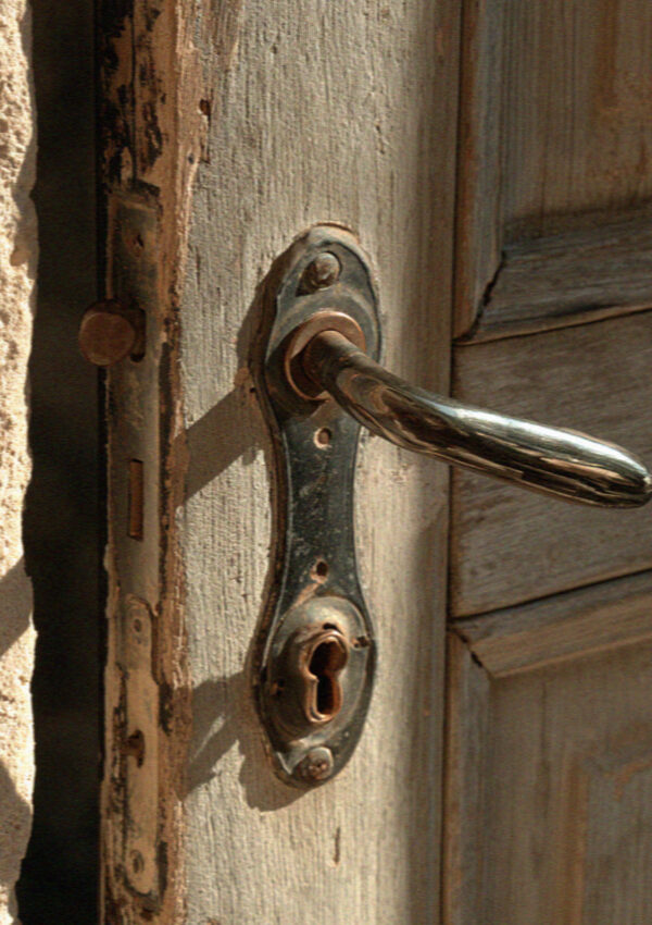 A worn iron handle on an old cave-house door in Matera