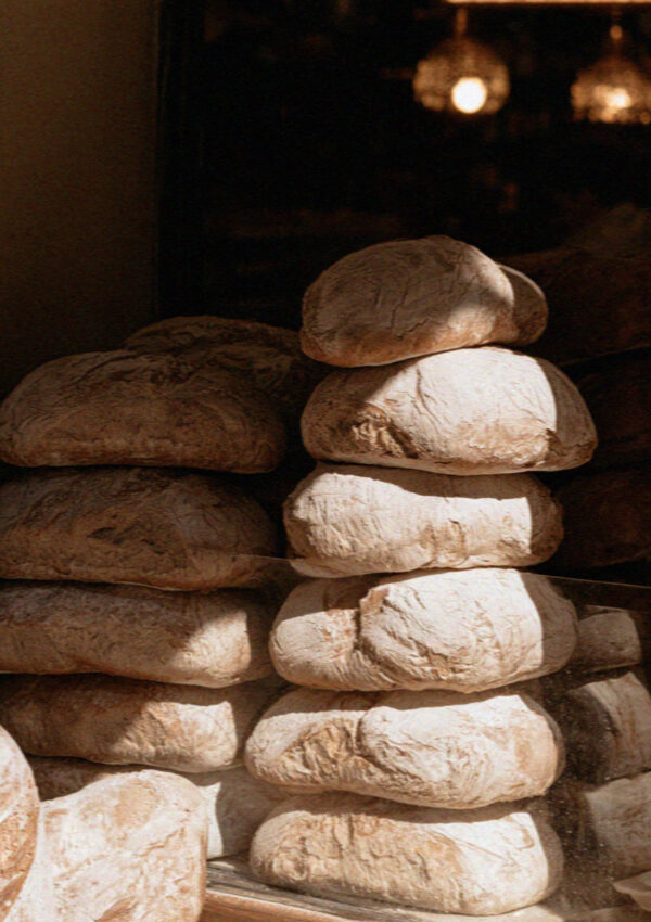 Stacked rustic loaves of bread in a bakery window