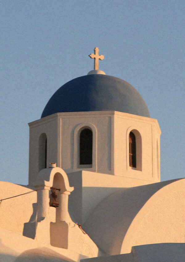 A blue-domed church in Santorini catching the last of the afternoon light