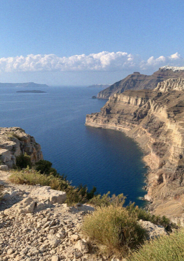 The striped cliffs of Santorini falling away to the water