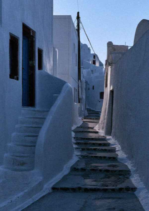 An empty whitewashed lane and steps in Megalochori, Santorini, at blue hour