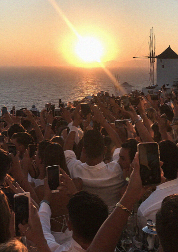 Phones raised into the sun for the sunset at Oia in Santorini