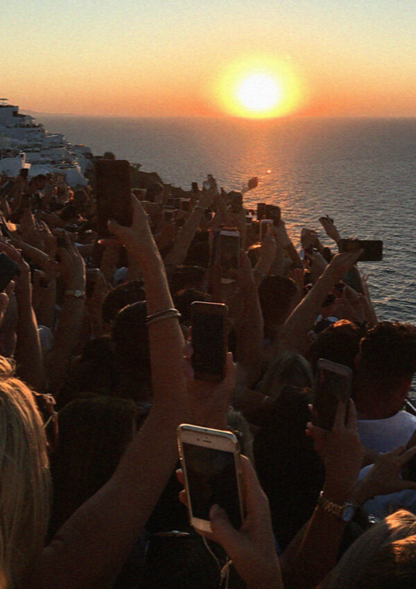Phones held up above the crowd for the sunset in Santorini