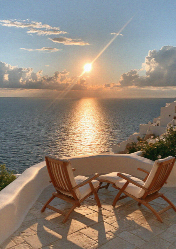 A terrace table above the caldera in Santorini as the sun goes down