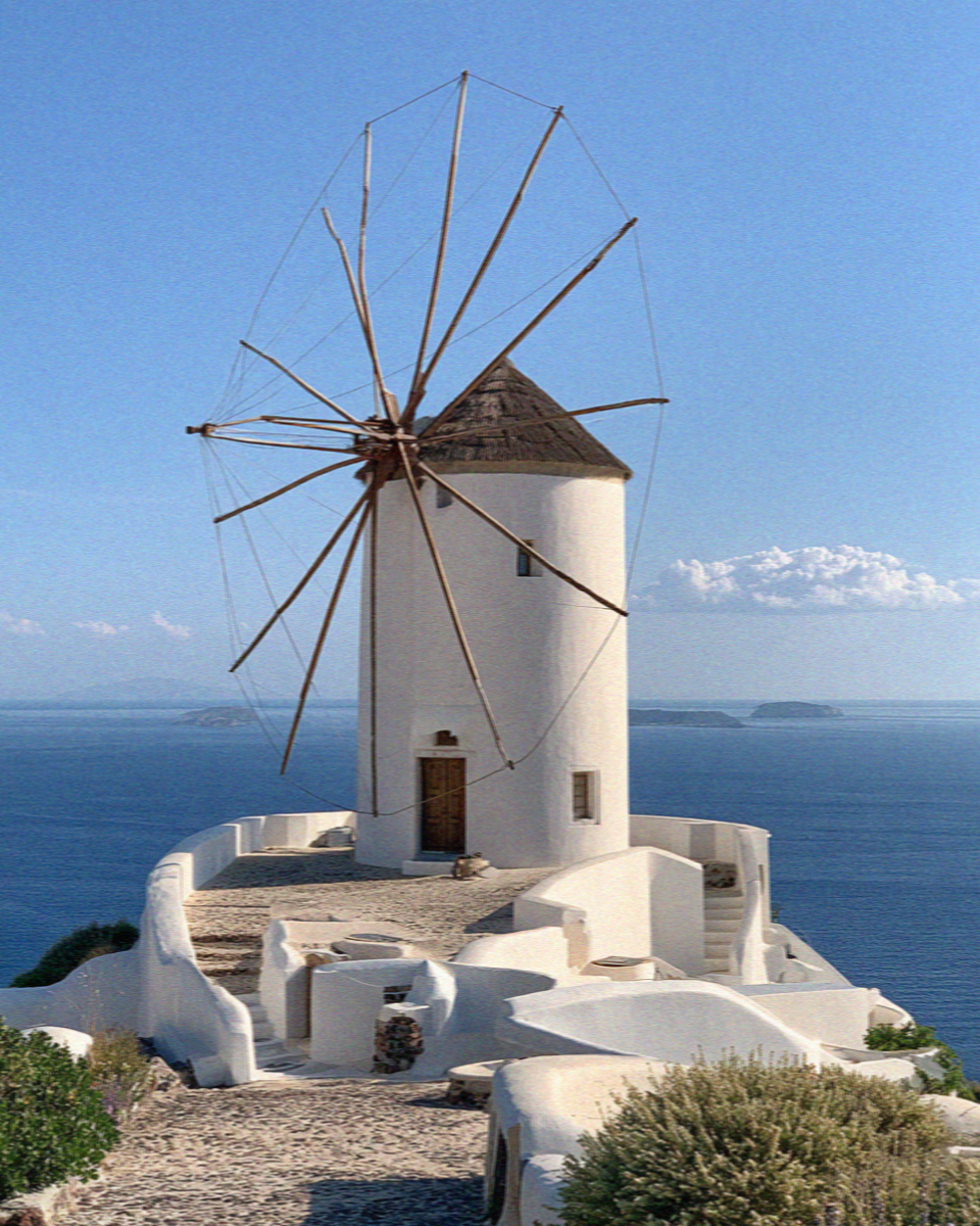 A whitewashed windmill above the sea in Santorini