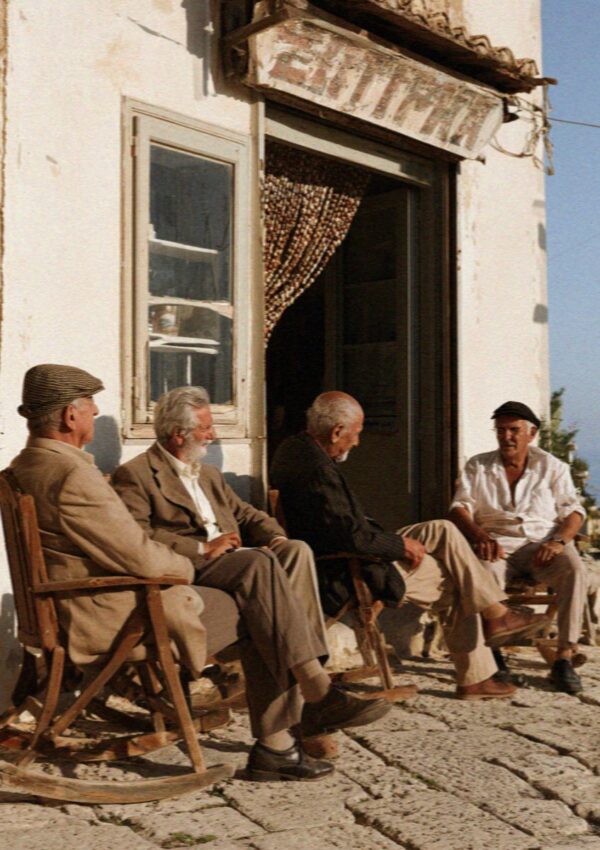 Four older men sitting outside the bar in the courtyard at Scopello, west of Palermo in Sicily