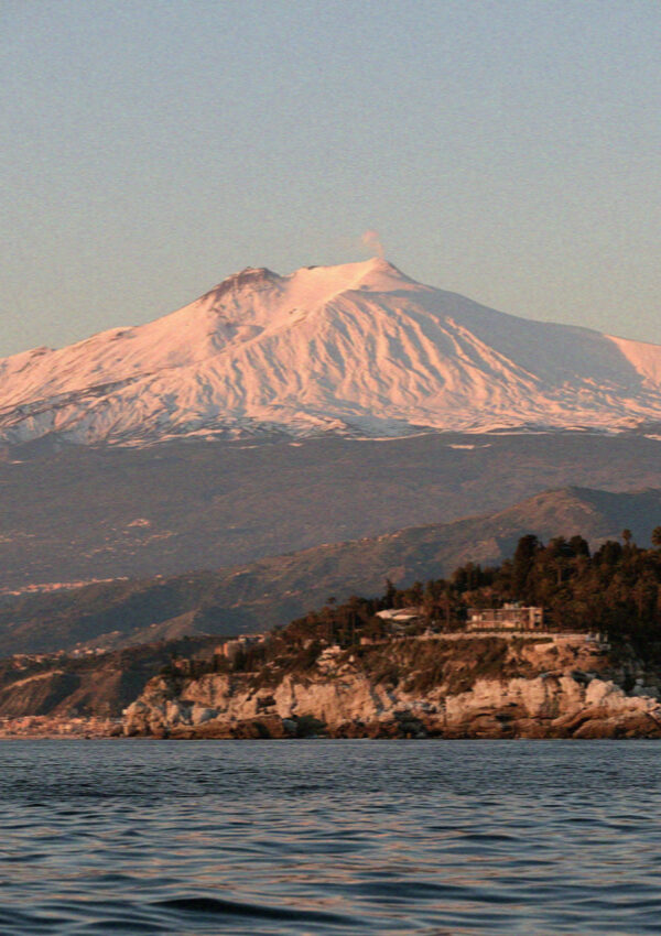Mount Etna seen from the water off Taormina in Sicily at dusk