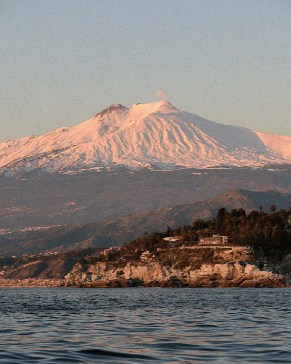 Mount Etna seen from the water off Taormina in Sicily at dusk