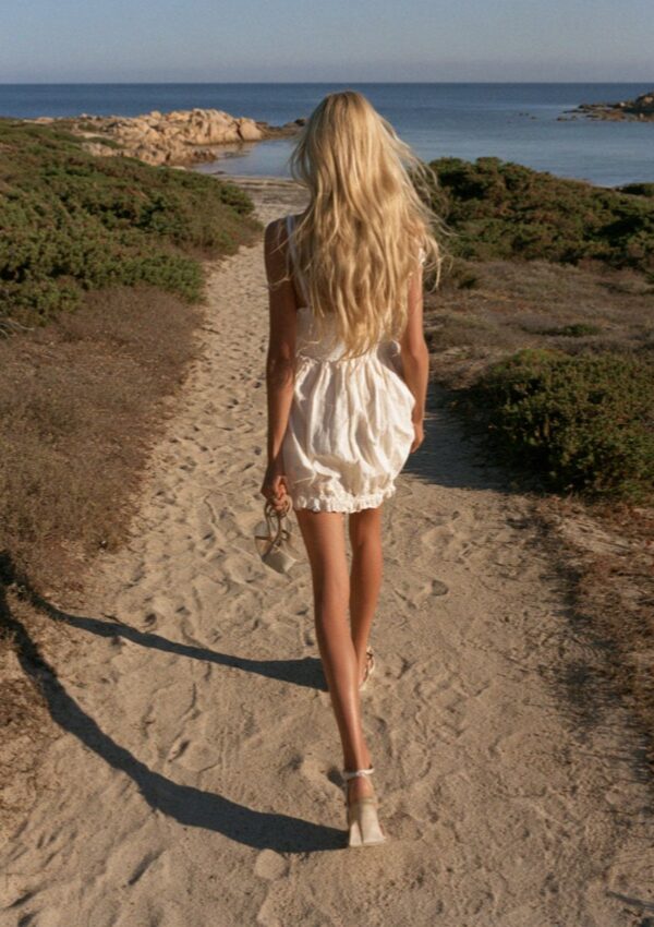 Victoria van der Berg walking down to an empty bay in the evening on the Costa Smeralda in Sardinia