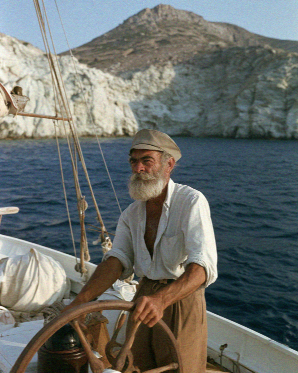 The captain at the wheel of the sailing boat off Milos
