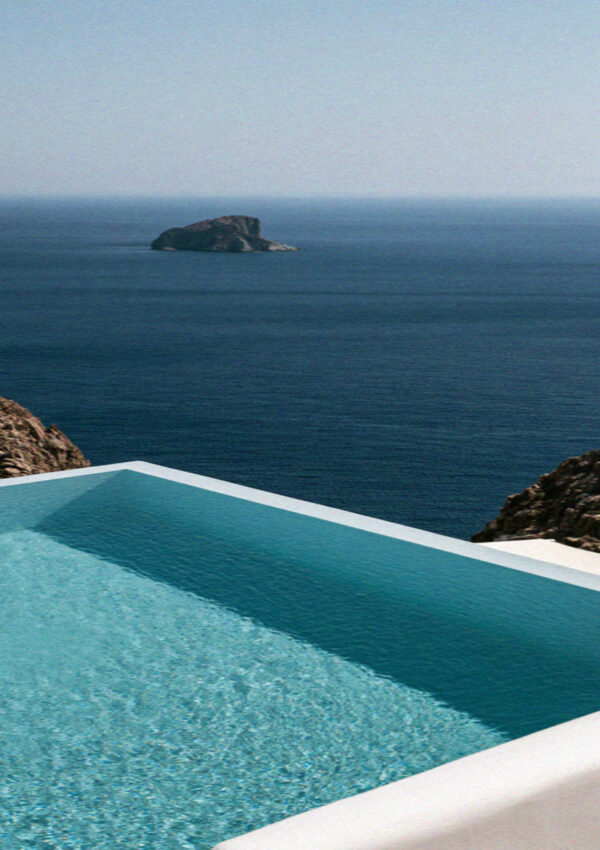 A villa infinity pool above the sea with a small island offshore on Mykonos