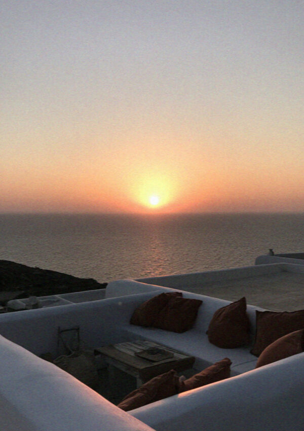 The sun sitting on the horizon over the sea seen from a villa terrace on Mykonos