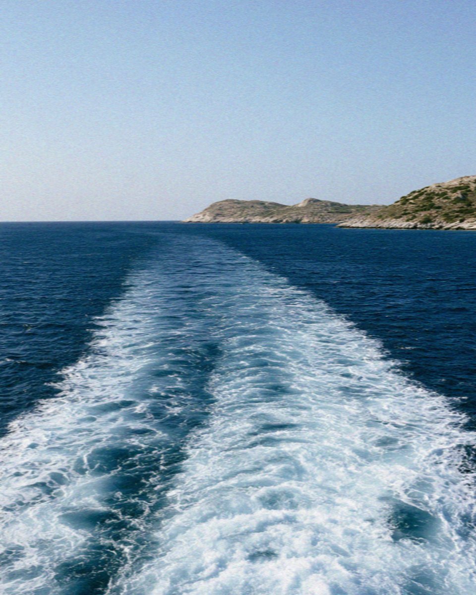 The white wake of the ferry stretching back towards Naxos
