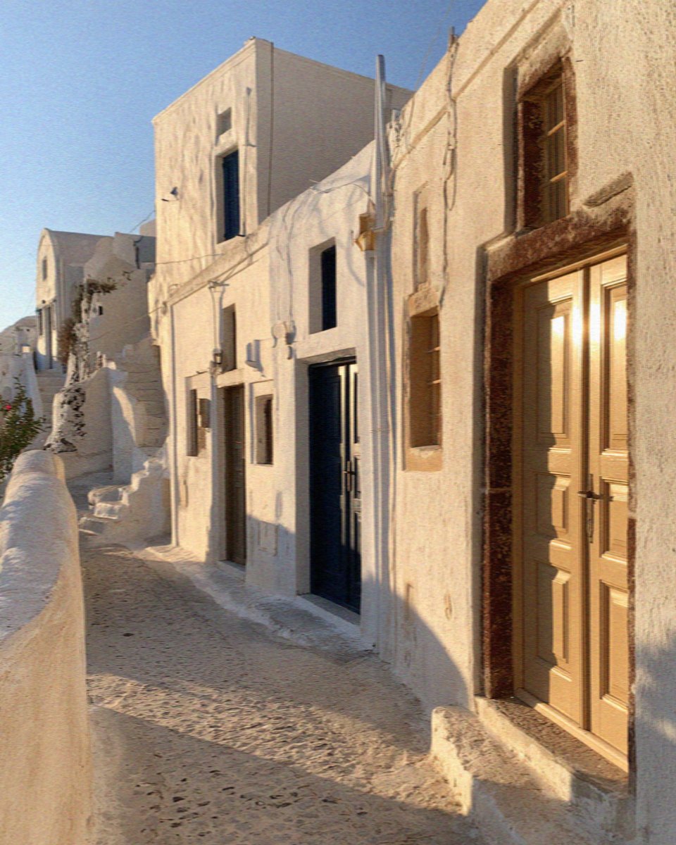 Whitewashed lanes and doorways of Pyrgos on Santorini in warm late afternoon light