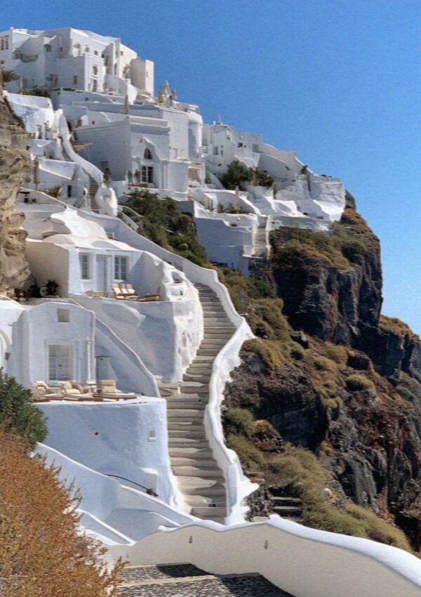 Whitewashed houses and steps climbing the caldera cliff on Santorini