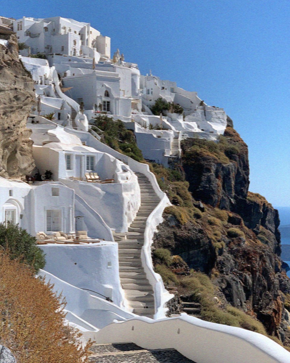 Whitewashed houses and steps climbing the caldera cliff on Santorini