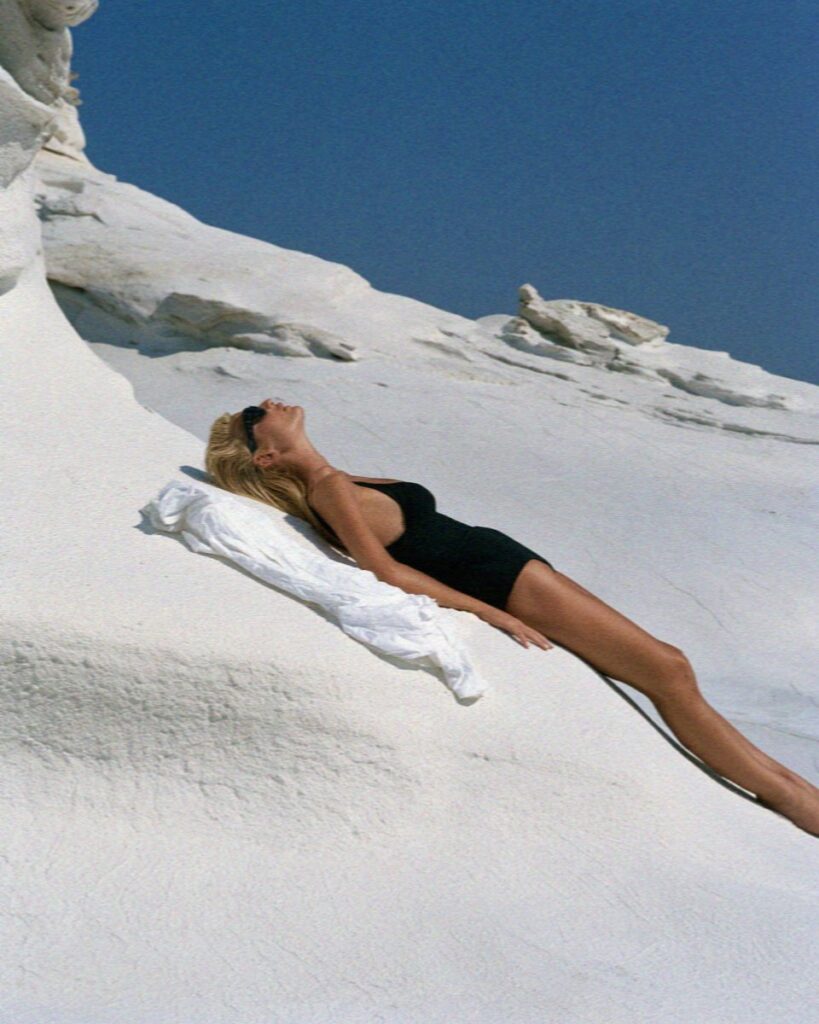 Victoria van der Berg lying on a towel on the white rock of Sarakiniko on Milos